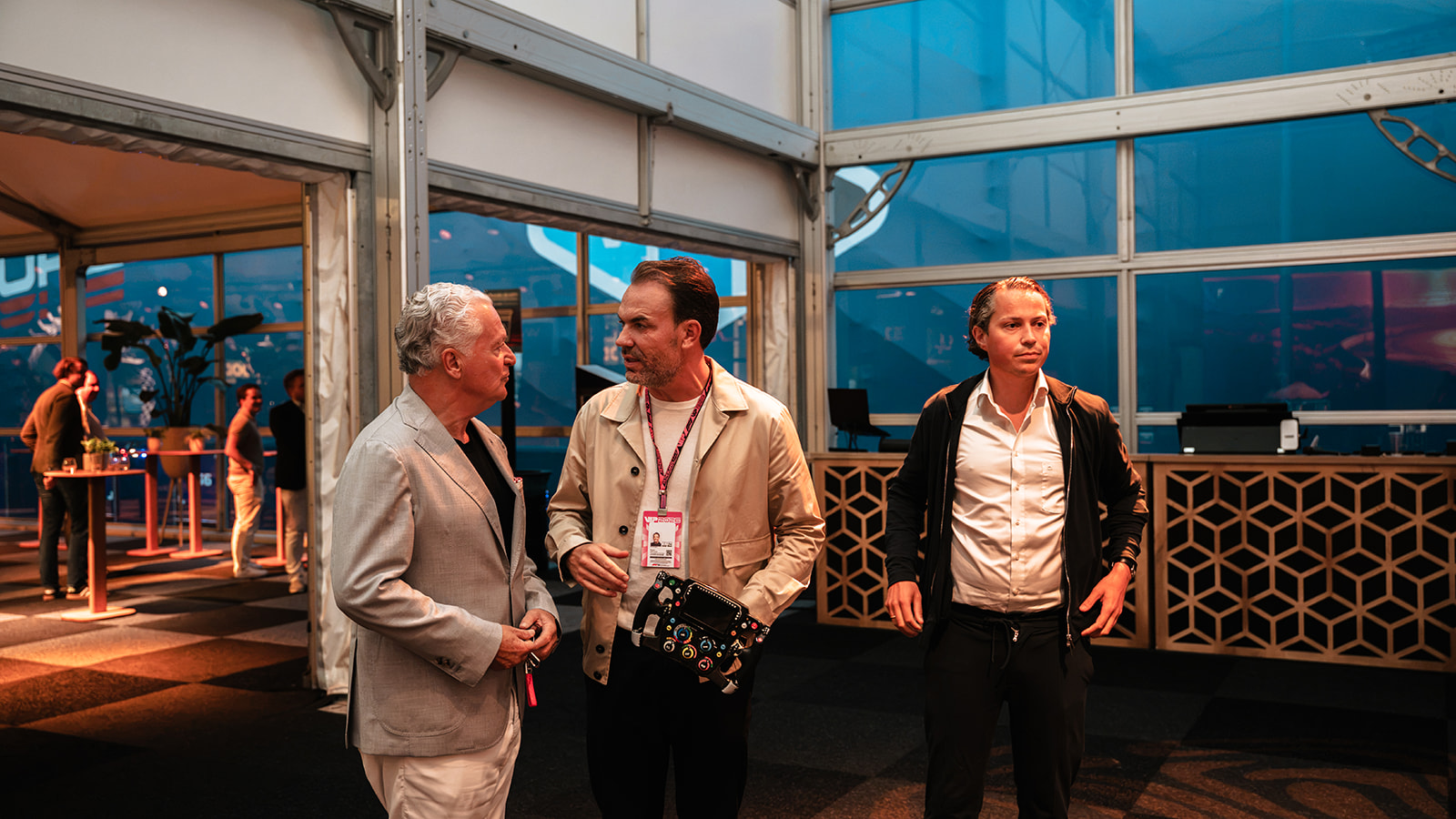 Drie gasten met een stuurwiel in de VIP-lounge